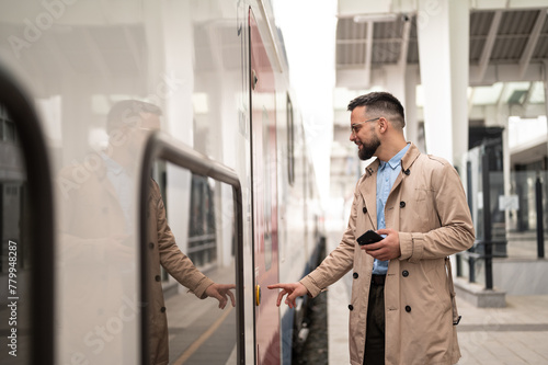 Man in train station entering in train looking on train doors