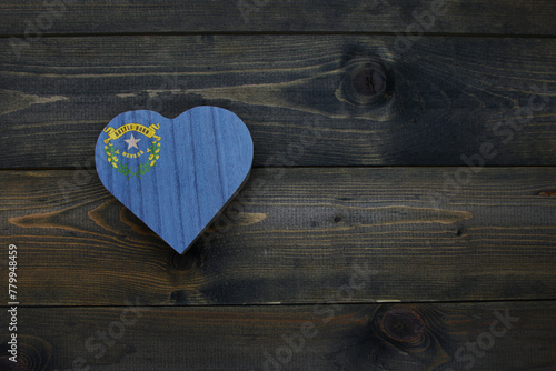 wooden heart with national flag of nevada state on the wooden background.