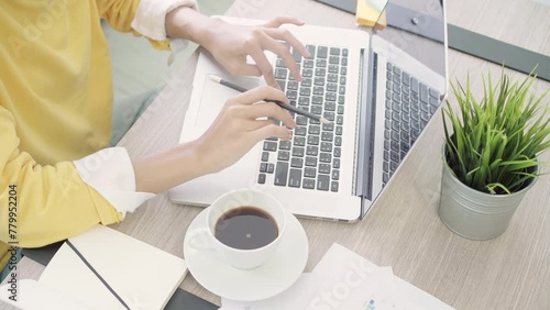 Beautiful young smiling asian woman working laptop on desk in living room at home