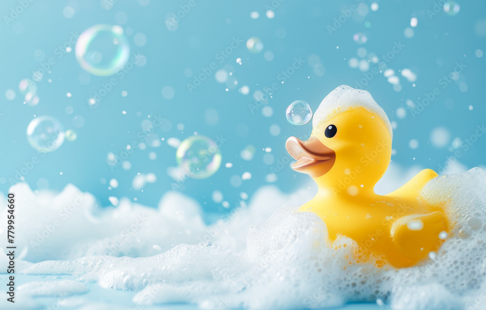 Yellow rubber duck in a soap foam on the light blue background with flying soap bubbles. Copy space. Yellow rubber duck in a soap foam on the light blue background with flying soap bubbles. Copy space.