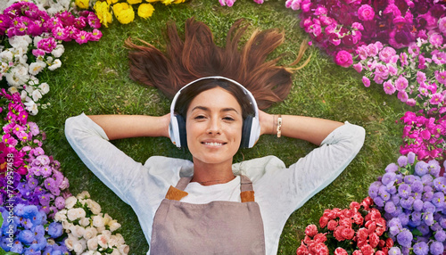 Ragazza felice ascolta musica rilassante distesa in mezzo ad un campo di fiori. photo