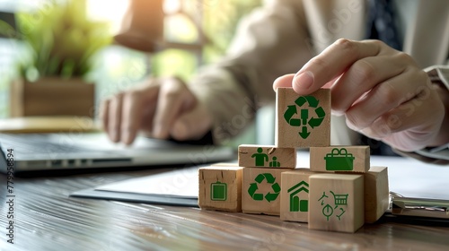 Professional hand placing wooden blocks with green recycling symbols. Office setting promoting sustainability. Eco-friendly business practices in a modern workplace. AI
