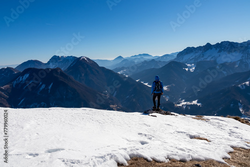 Man on panoramic hiking trail on way to snow covered mountain peak Ferlacher Horn in Carinthia, Austria. Alpine landscape of Austrian Alps. Wanderlust in tranquil serene nature. Winter wonderland © Chris