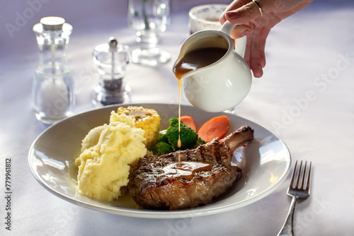 Steak dish with gravy being poured