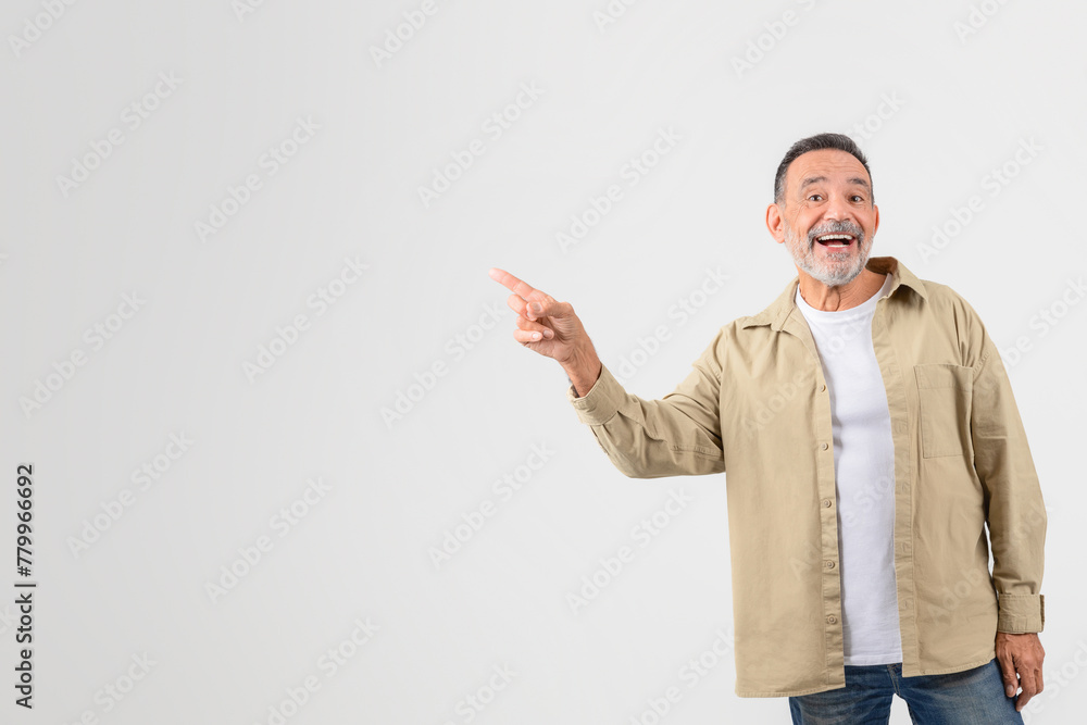 Senior man pointing while looking away at copy space Senior man pointing while looking away at copy space