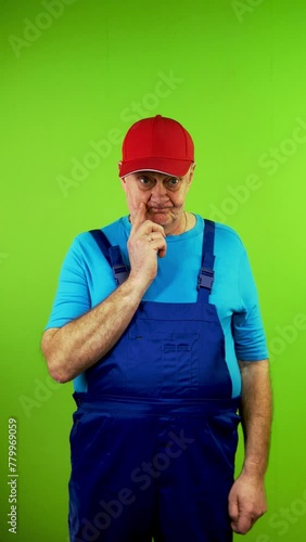 Repairman in overalls thinks scratches head, shrugs shoulders, no understand. photo