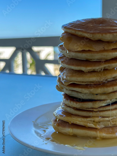 Close up of tall pancake stack with honey drips