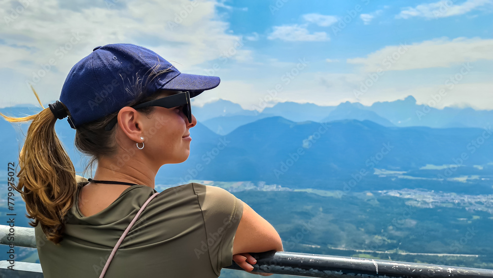 Woman with scenic view from the viewing platform red wall (Rote Wand) in the alpine garden of Dobratsch, Villacher Alps, Carinthia, Austria, Europe. Massive cliff overlooking the mountains of alps Woman with scenic view from the viewing platform red wall (Rote Wand) in the alpine garden of Dobratsch, Villacher Alps, Carinthia, Austria, Europe. Massive cliff overlooking the mountains of alps