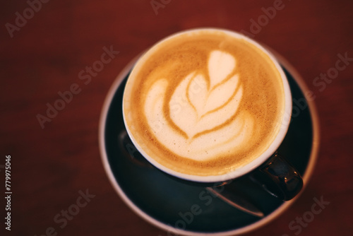 cup of cappuccino with latte art on wooden table