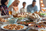 A family is gathered around a table with a variety of food, including pizza