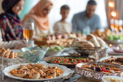 A family is gathered around a table with a variety of food  including pizza