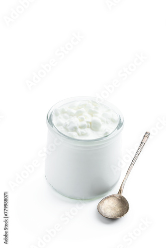 Granular cottage cheese with cream in a glass jar isolated on white © lena_zajchikova