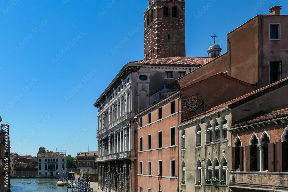 Floating boats with panoramic view of a water channel in city of Venice, Veneto, Italy, Europe. Venetian architectural landmarks and old houses facades along water canal. Urban tourism in summer