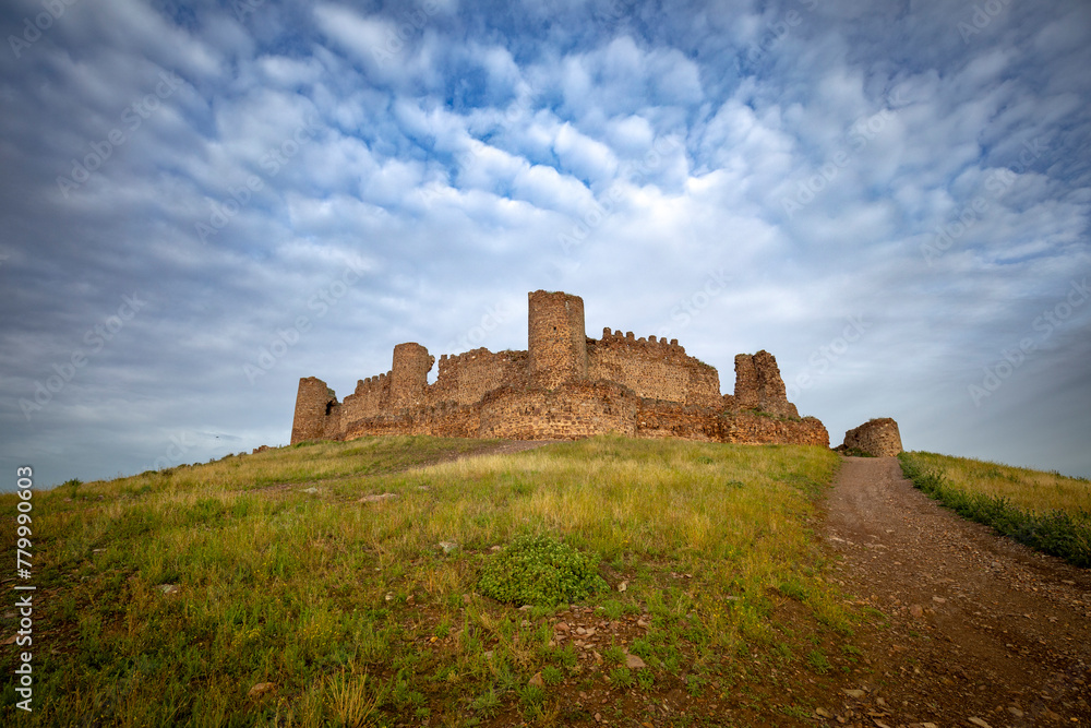 Panoramic view of the medieval walled castle of Almoacid in Toledo, Castilla la Mancha, Spain, with morning light and beautiful clouds