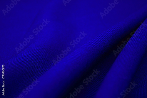 Blue fabric closeup. Plexus threads. Clothing industry. Abstract background. Textile waves.