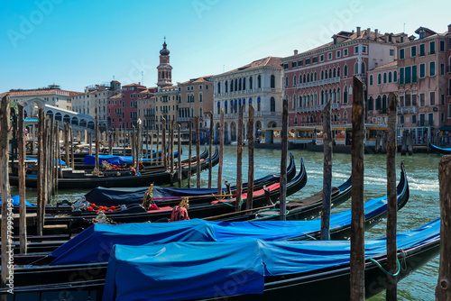 Group of gondolas moored in channel Canal Grande near the famous Rialto bridge in city of Venice, Veneto, Northern Italy, Europe. Venetian architectural landmarks. Romantic vacation photo