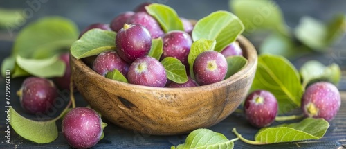   A wooden table holds a bowl filled with ripe plums, encircled by verdant leaves above Nearby, a leafy branch extends