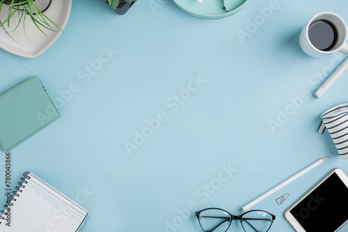 A tidy workspace with office supplies and a cup of coffee on a blue background.