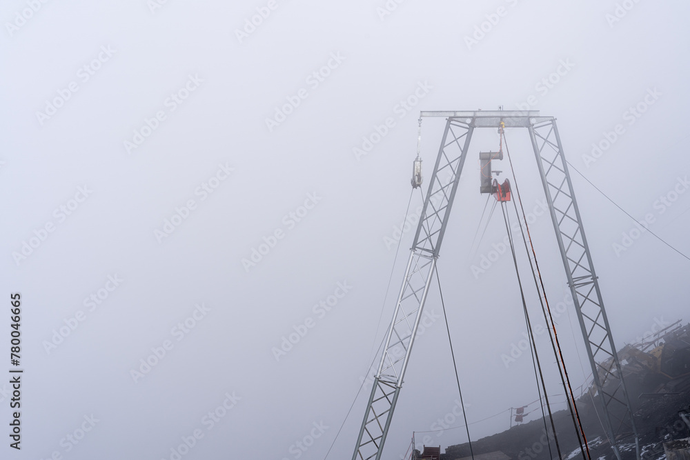 Cable car pylon in dense fog in Switzerland. Copy space on the left