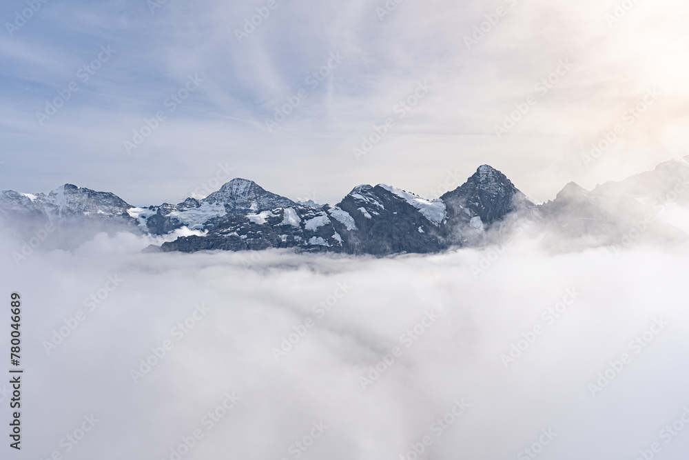 View of Swiss Alps over clouds on a bright sunny day from Schilthorn summit in Switzerland