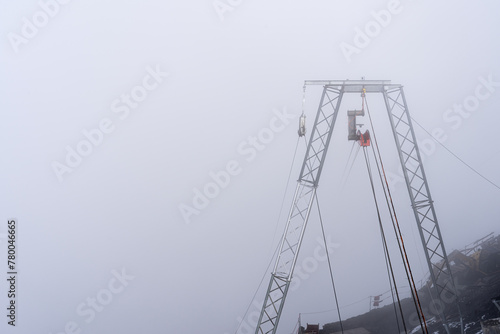 Obraz na płótnie Cable car pylon in dense fog in Switzerland. Copy space on the left w salonie