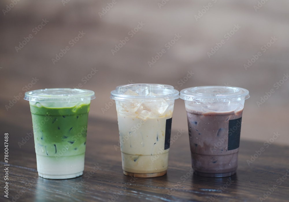 Close up glass of ice matcha green tea, iced latte and ice chocolate on wooden table of a coffee shop summer terrace, menu photography. Close up glass of ice matcha green tea, iced latte and ice chocolate on wooden table of a coffee shop summer terrace, menu photography.