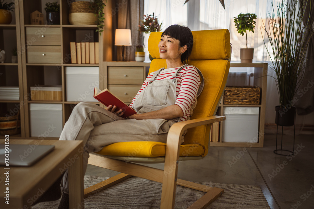one female mature japanese woman read book at home one female mature japanese woman read book at home