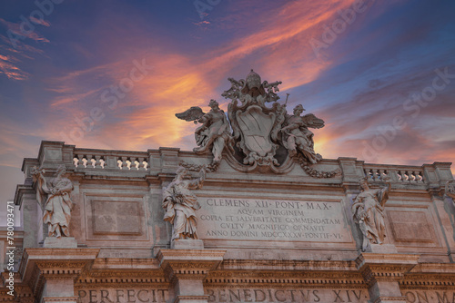 Historical facade featuring ornate sculptures, crest with papal tiara and keys, Latin inscriptions commissioned by Popes Clement XII and Benedict XIV in 1735 and 1747, likely in Rome. photo
