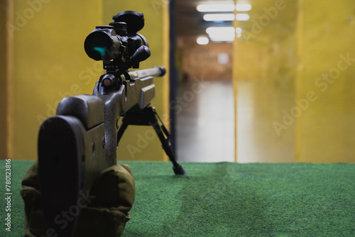 A sniper rifle with an optical sight and a bipod in a shooting range. photo