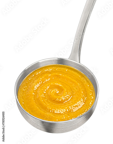 Metal ladle with pumpkin cream soup isolated on white background