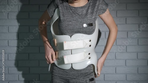 Girl wearing scoliosis brace. A view of plastic orthopedic corset on the teen back during treatment period. photo