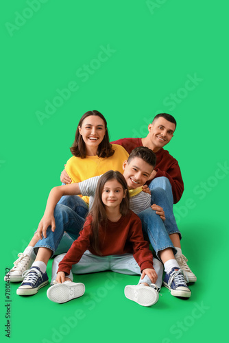 Little children with their parents sitting on green background © Pixel-Shot