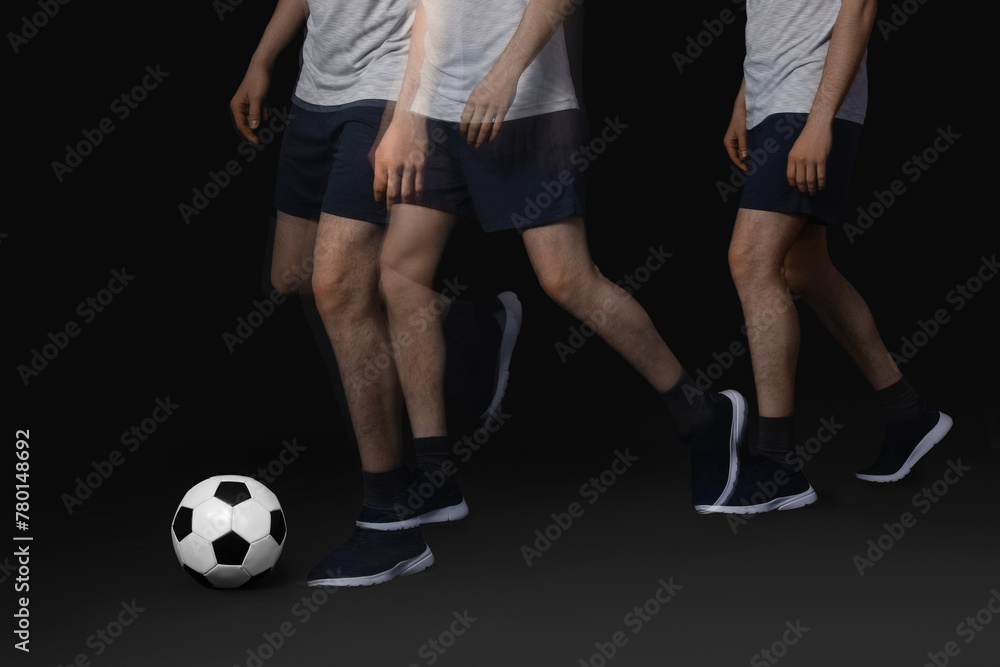 Fototapeta premium Man playing with soccer ball in motion on black background