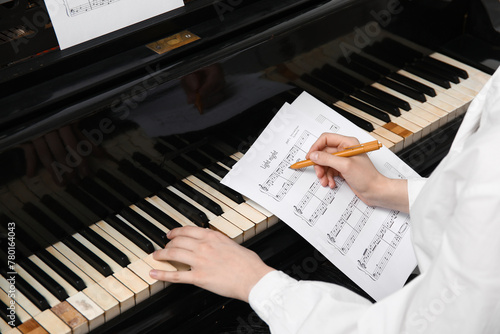 Woman playing piano and wri...