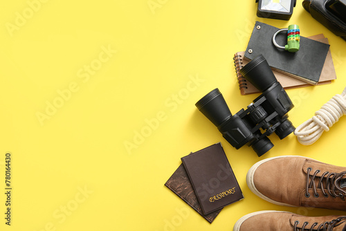 Set of travel items, passports and notebooks on yellow background