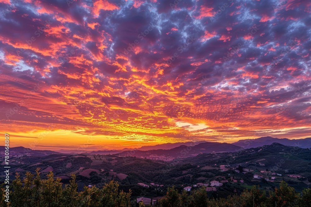 Vibrant fiery sunset sky with orange, pink, purple and yellow colors, panoramic landscape