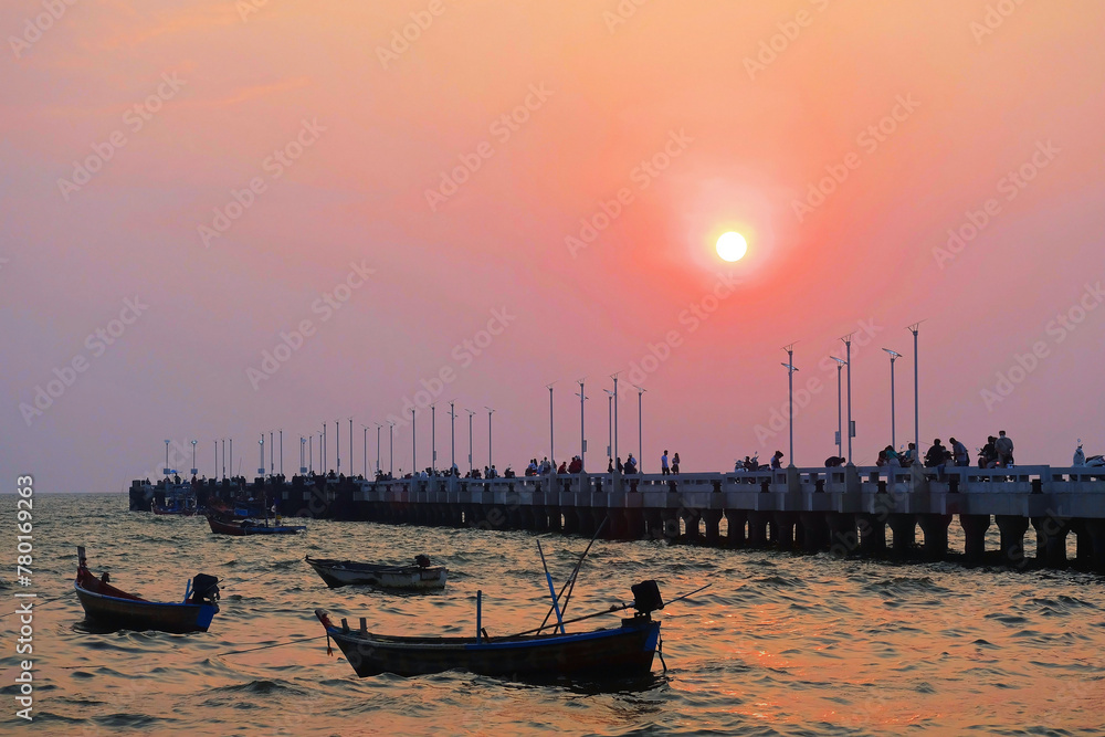 Sunset over the long bridge and boats at the sea, Bangsaen, Chonburi Province, Thailand