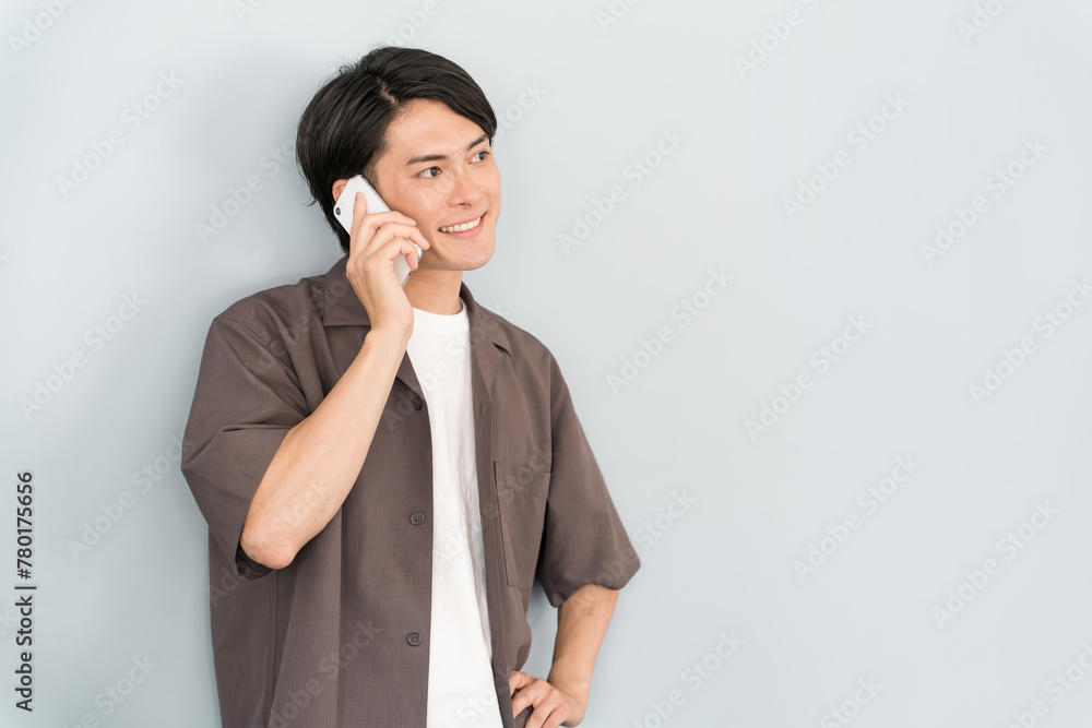 スマホで通話・電話する若いアジア人男性
スマホで通話・電話する若いアジア人男性