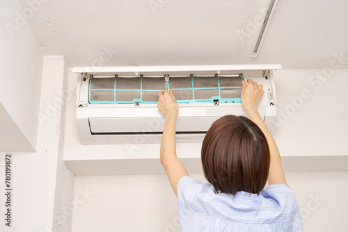 エアコンのフィルター掃除をする女性
