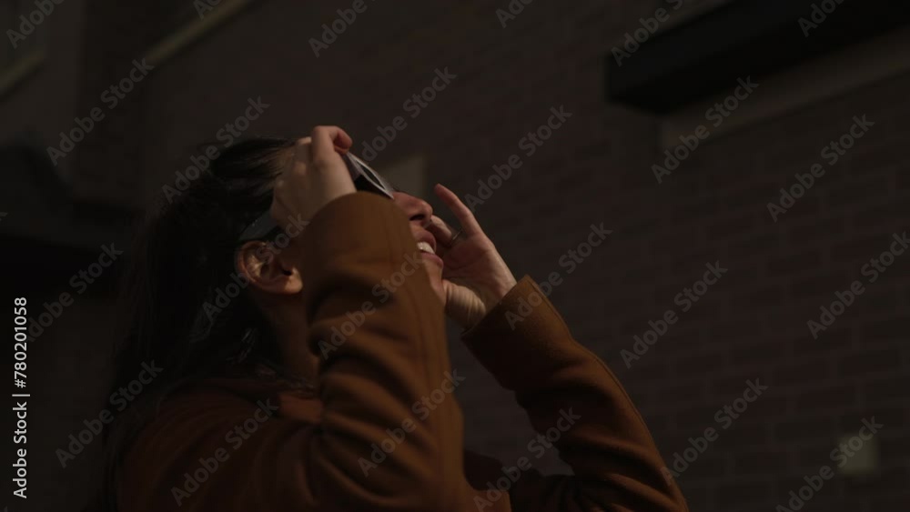 Woman watching solar eclipse event in front of home