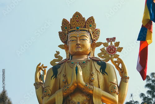Ornate golden Avalokitesvara female Buddha statue against a clear blue sky background in Swayambhu Buddha Park Ring Road which is a popular tourist destination in Kathmandu, Nepal