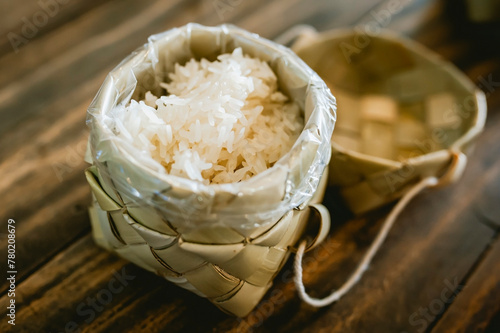 White sticky rice in a basket woven with palm leaves.
