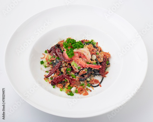 Black pasta stir fried chilli with shrimp topped with parsley, dried chilli, sliced spring onion, fried garlic, and cheese. Black spaghetti made from the ink in the squid.