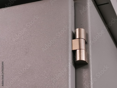 Selective focus on close up image of electrical cabinet door with hinges.