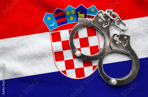 Flag of Croatia and police handcuffs. Crime and offenses in country Concept
