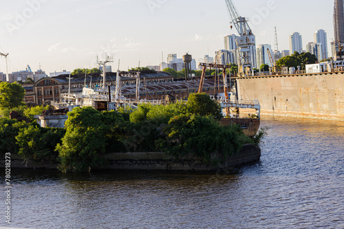 Barcon inmovil en costa del Rio Darsena Sur con plantas al lado photo