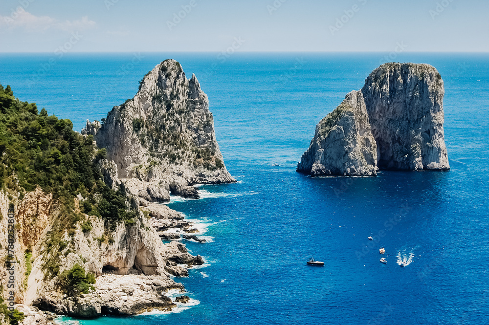 Natural rock arches and cliffs on the coast Sorrento and Capri, Italian islands with crystal clear waters where tourist boats crowd to photograph them in summer.