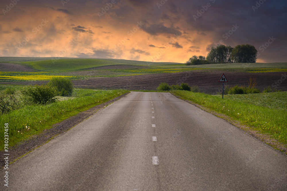 Asphalt road running through countryside landscape