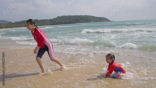 slow motion of two happy kids playing on the Riyue bay at Wanning Hainan China photo