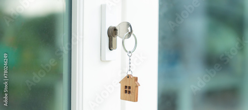 Landlord key for unlocking house is plugged into the door. Second hand house for rent and sale. keychain is blowing in the wind. mortgage for new home, buy, sell, renovate, investment, owner, estate © Shisu_ka
